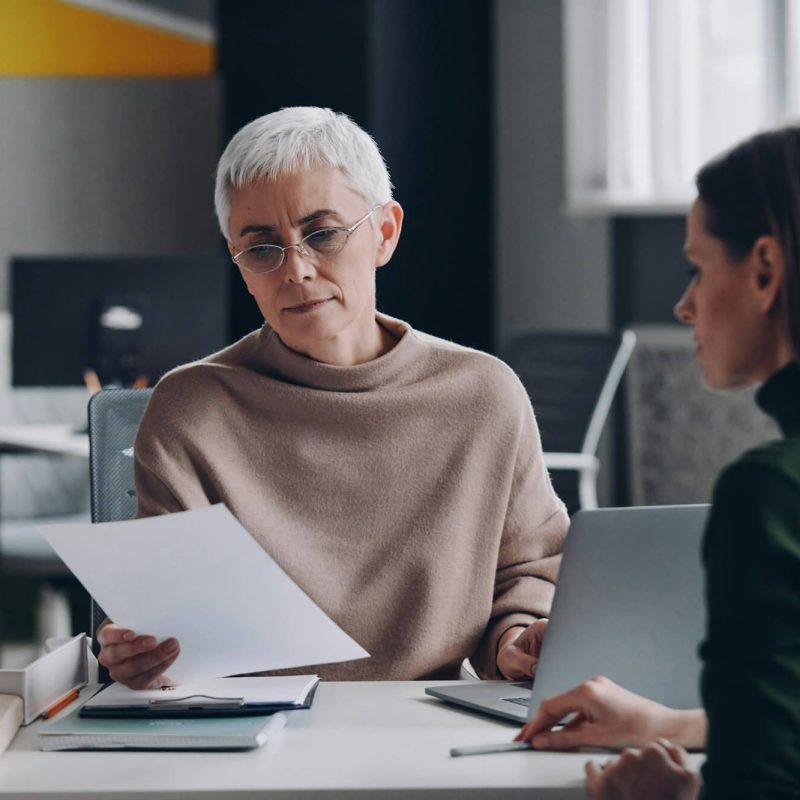 senior-female-hr-manager-examining-application-while-having-interview-with-young-woman.jpg